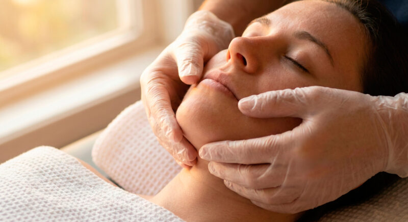 Manuelle Therapie bei CMD in Dortmund: Physiotherapeut führt Kiefergelenksmobilisation zur Linderung von Kieferschmerzen durch.